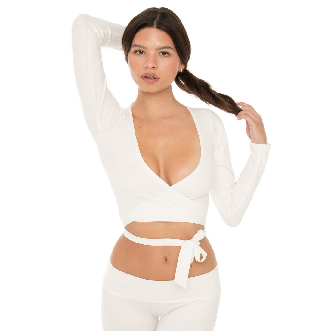 Model wearing the white wrap top with one arm raised and hair pulled back, highlighting the neckline and wrap detail. **white