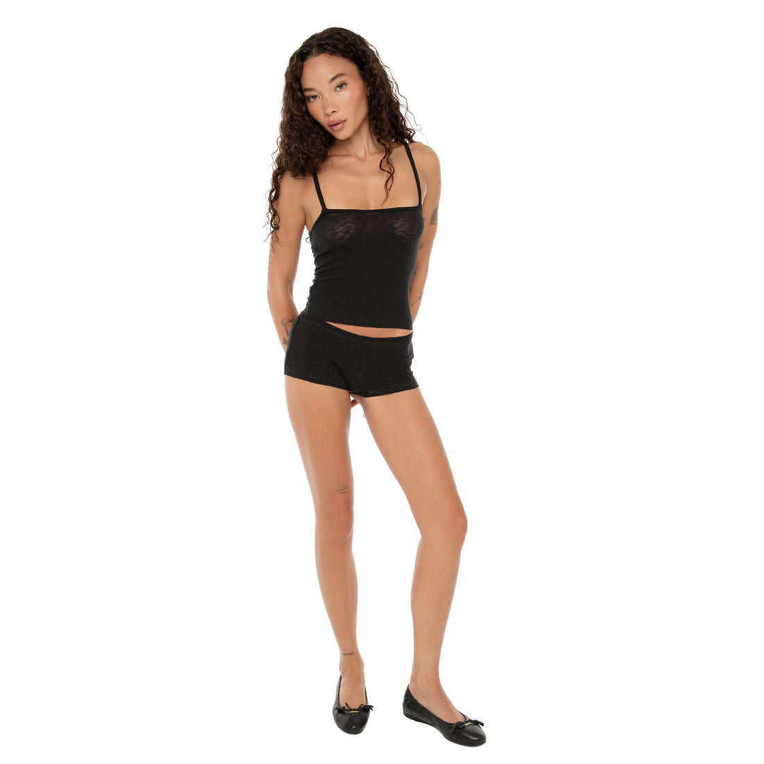 Model wearing the Aili Short in black with matching tank, front view standing with arms behind back. **black