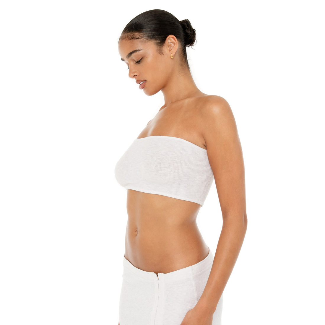 Model wearing the Aili Tube — a minimalist ribbed knit tube top crafted from recycled cotton, offering a snug, barely-there fit that contours to your silhouette**white