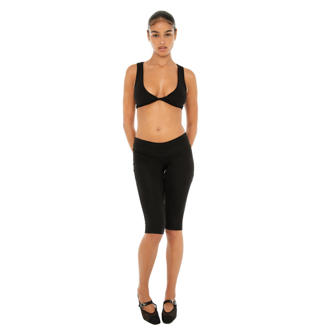Front view of Alue Top in black, modeled with coordinating black leggings **black