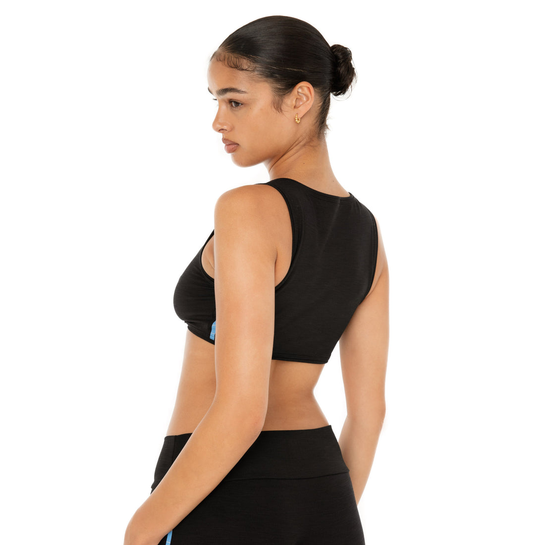 Back view of Alue Top in black, modeled with coordinating black leggings **black