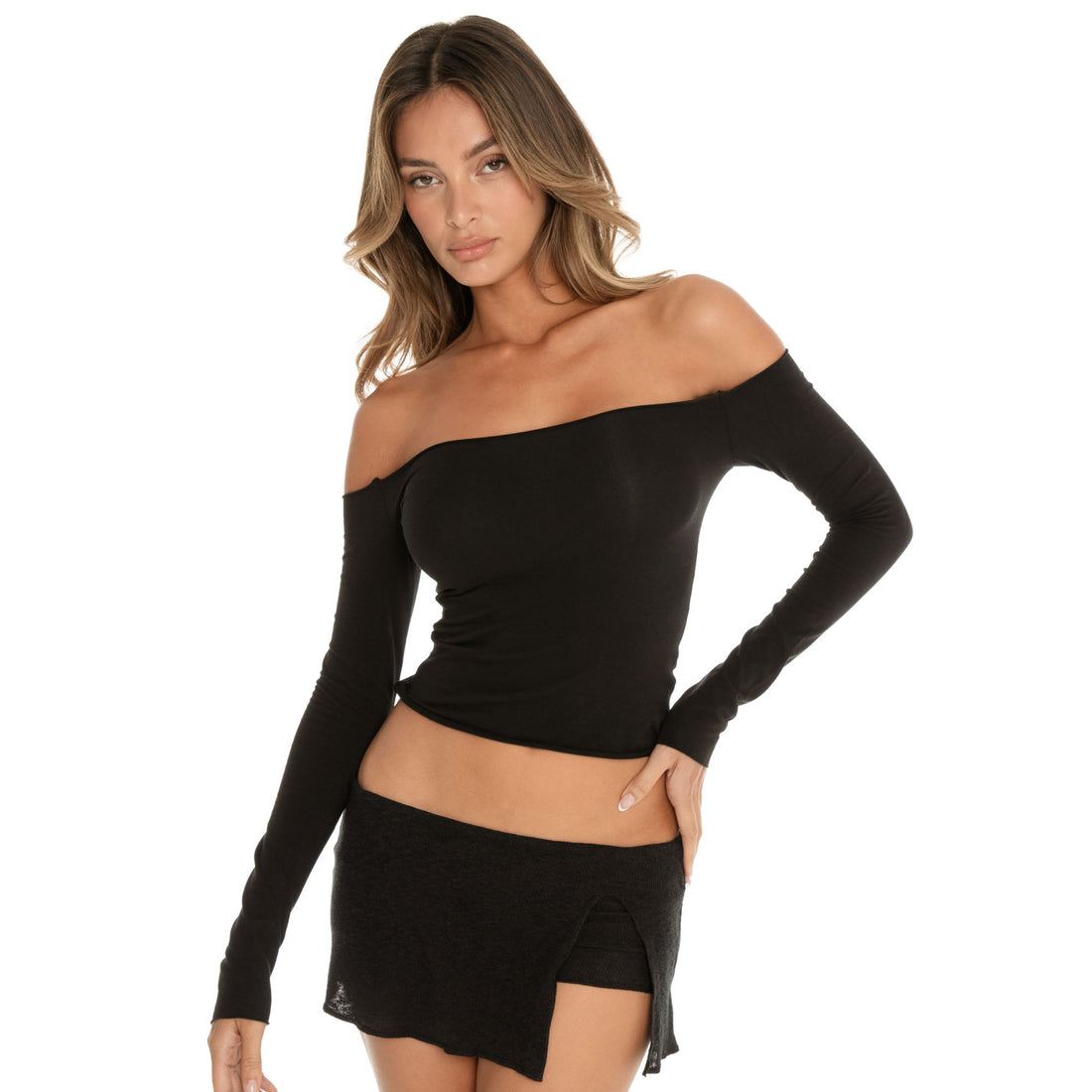 Front-facing model wearing the Anouck Top in black styled with a black low rise skort, relaxed pose with hand on hip **black