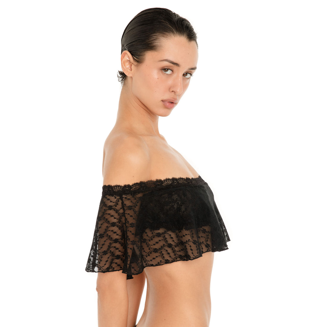 Side view of the Liulu Top in black, showing the sheer floral lace, off shoulder neckline and draped ruffle silhouette. **black