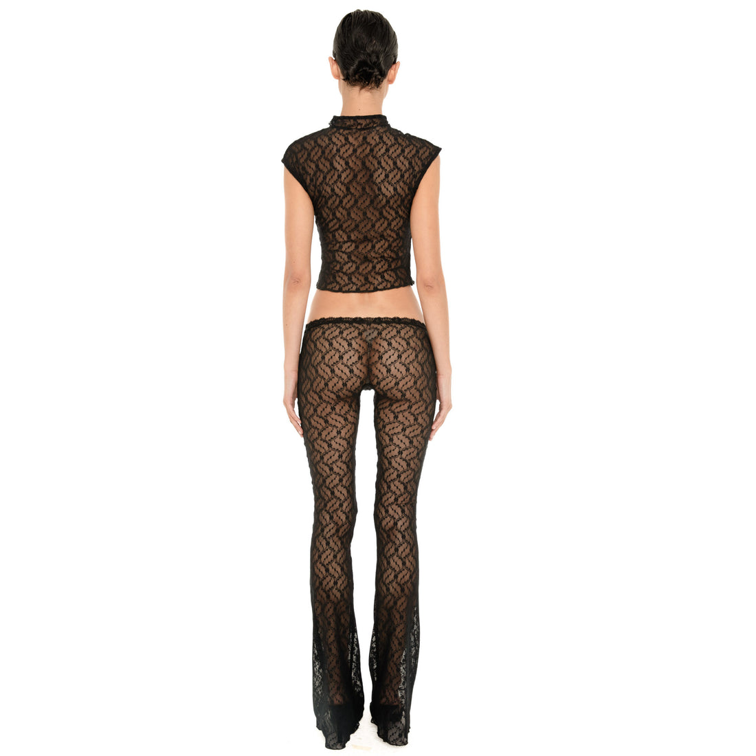 Back view of the Liani Pant in Black, showing the sheer floral lace, low rise waistband and slim flared silhouette. **black