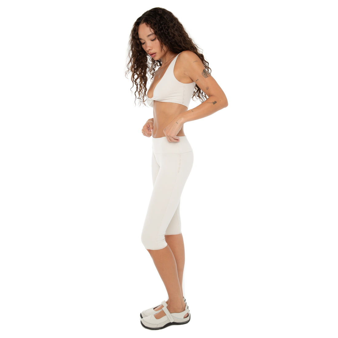 Side view of Clio Capri leggings in sand with low waistband. **sand