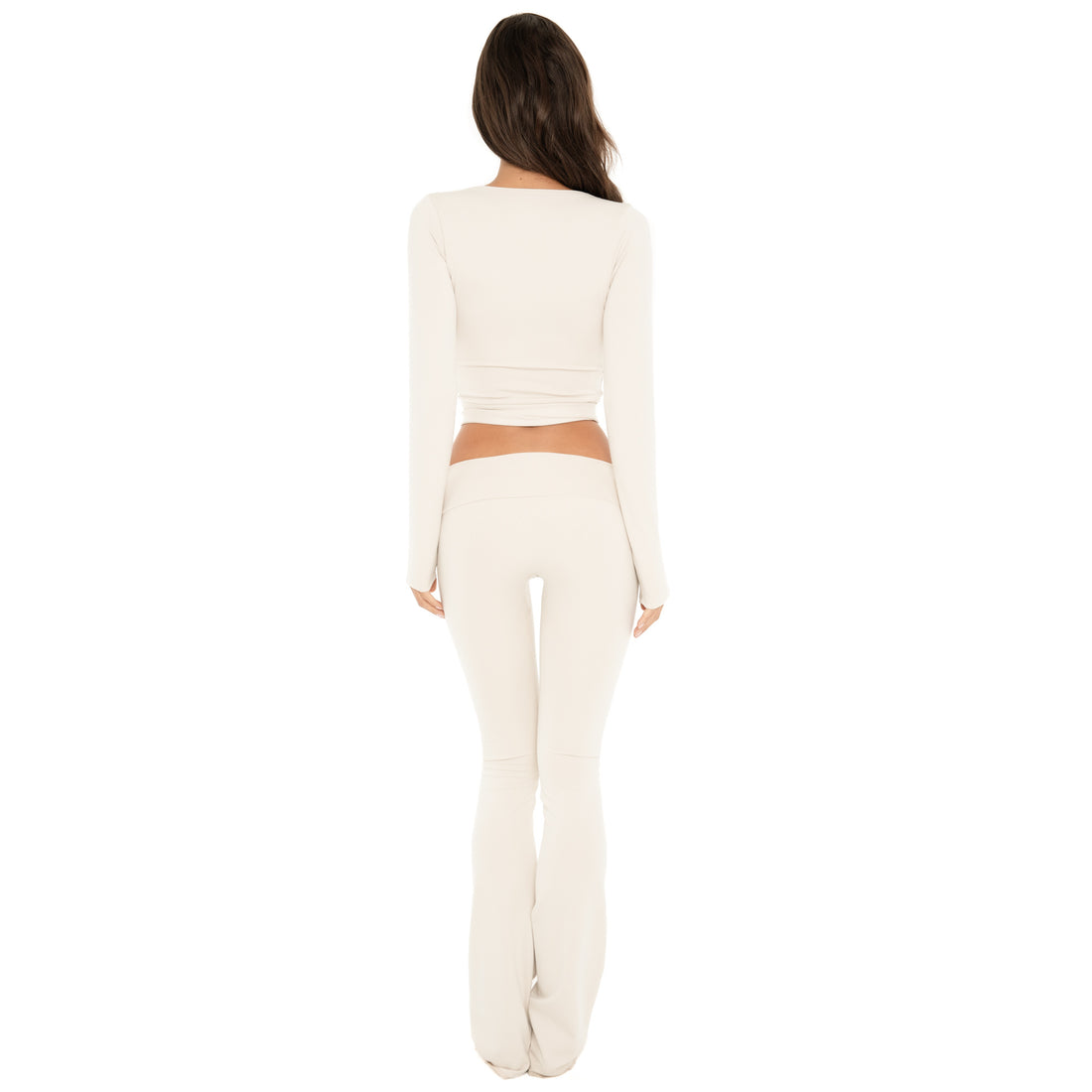 Back view: Back view of the sand Clio Pant, showing the wide fold-over waistband and fitted shape through the hips and legs. **sand