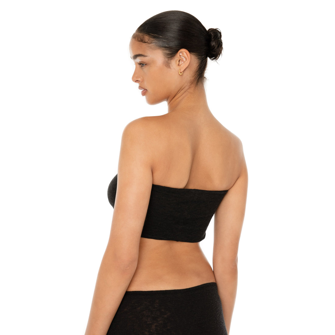 Back three quarter view of the black Aili Tube highlighting the straight strapless back and close fit **black