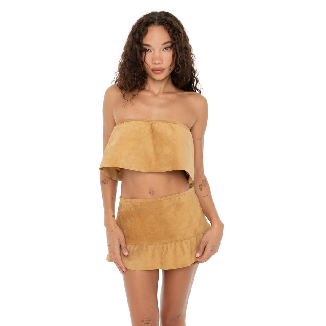 Model posing with hands on skirt waistband, emphasizing the drop-waist and flounced hem **butterscotch