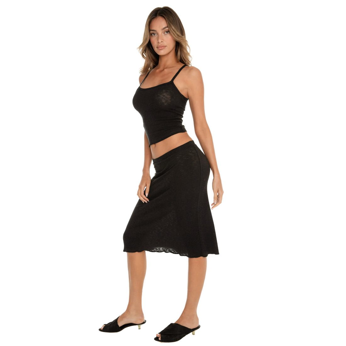 black ribbed midi skirt with slight flare, walking pose emphasizing lightweight semi sheer fabric **black
