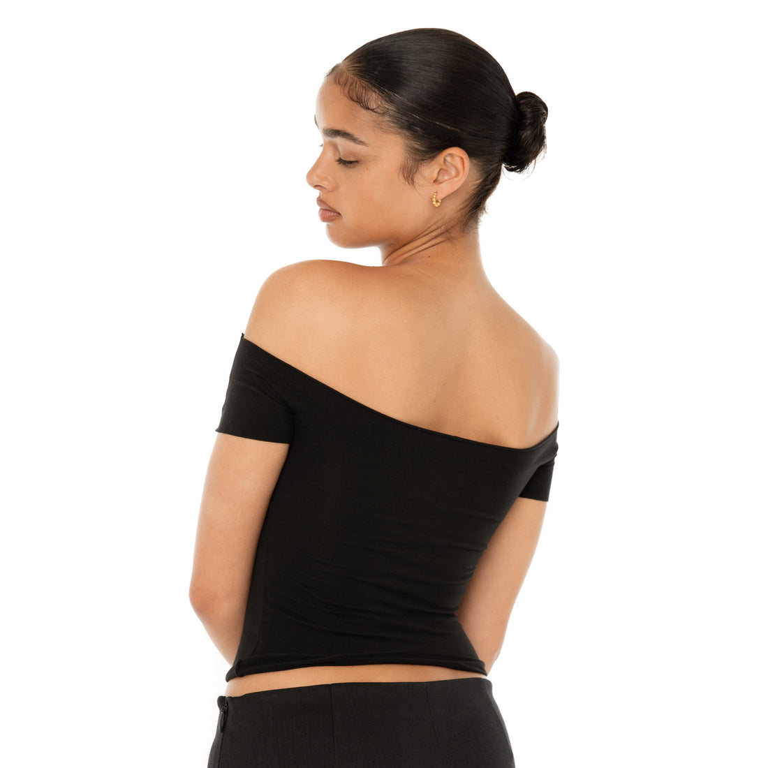 Model wearing the Ilze Top in white, an off-the-shoulder fitted jersey top made of lightweight cotton-spandex blend with raw hems **black