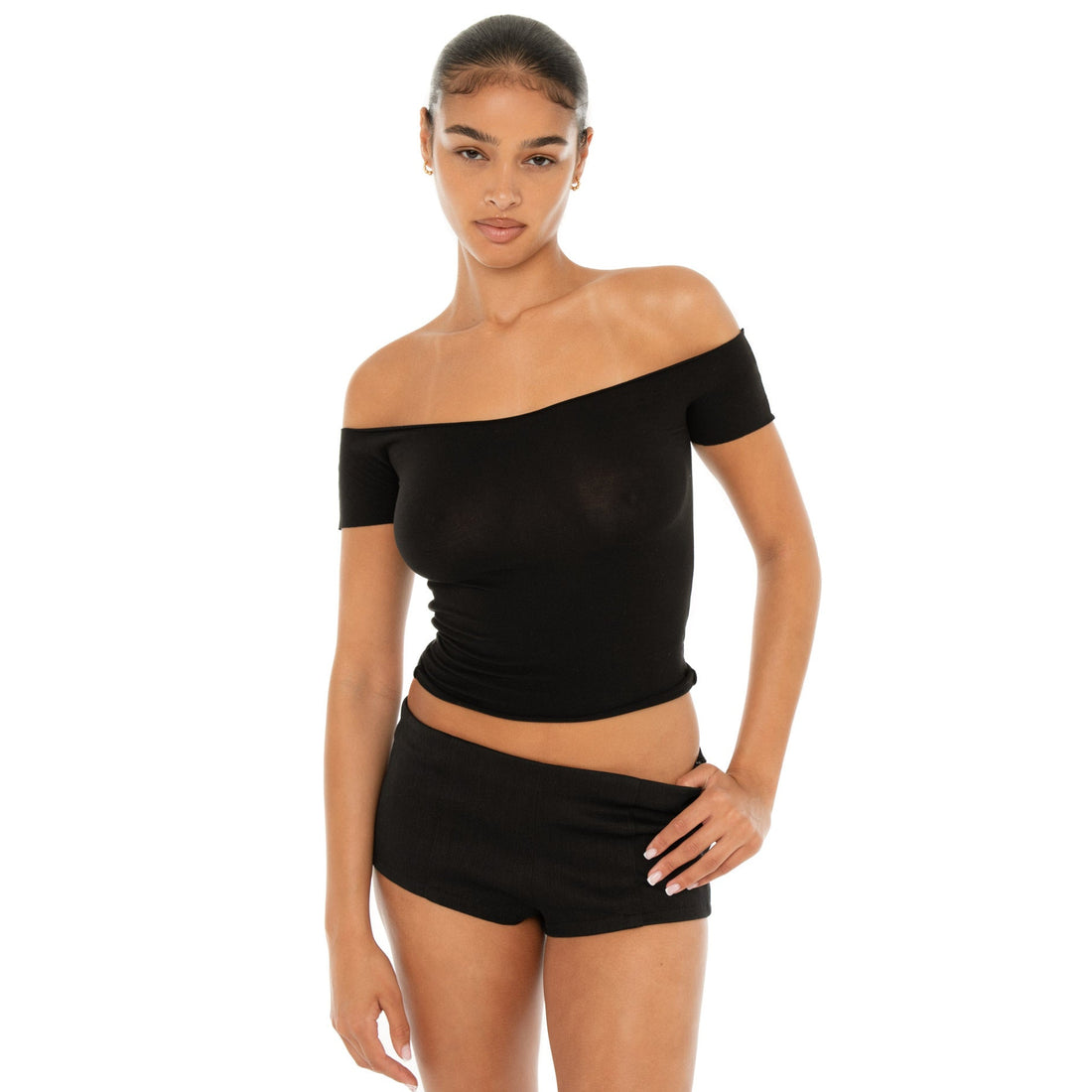 Model wearing the Ilze Top in white, an off-the-shoulder fitted jersey top made of lightweight cotton-spandex blend with raw hems **black