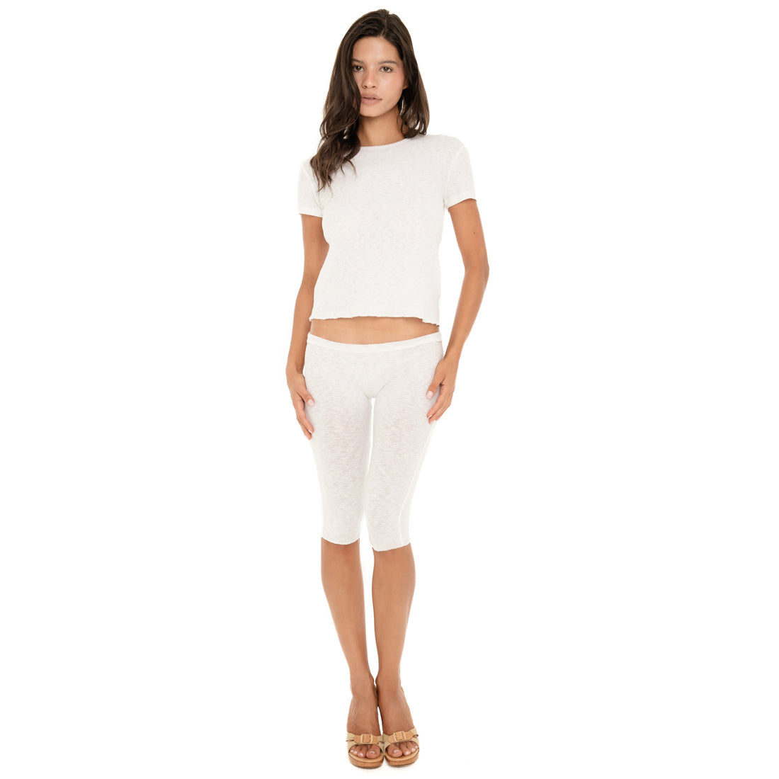 Full-length front view of the Kimi Tee in White, a loose cropped short-sleeve tee, styled with the Illi Capri in White and sandals **white