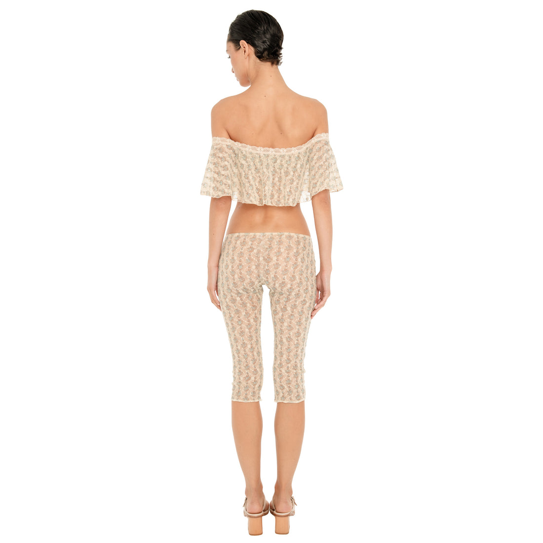Back view of the cream sheer floral lace Lyli Capri, showing the sheer floral pattern, low rise waist, and fitted knee length silhouette, worn with the matching off shoulder top. **sky blossom