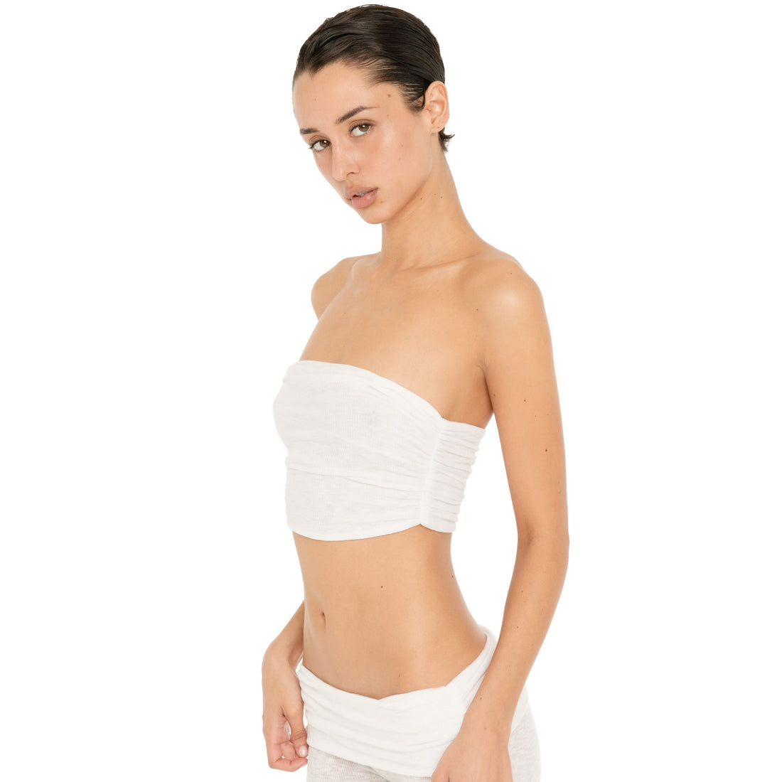 Three-quarter view of model wearing the Meili Bandeau in White, showing the softly gathered front and fitted cropped silhouette. **white