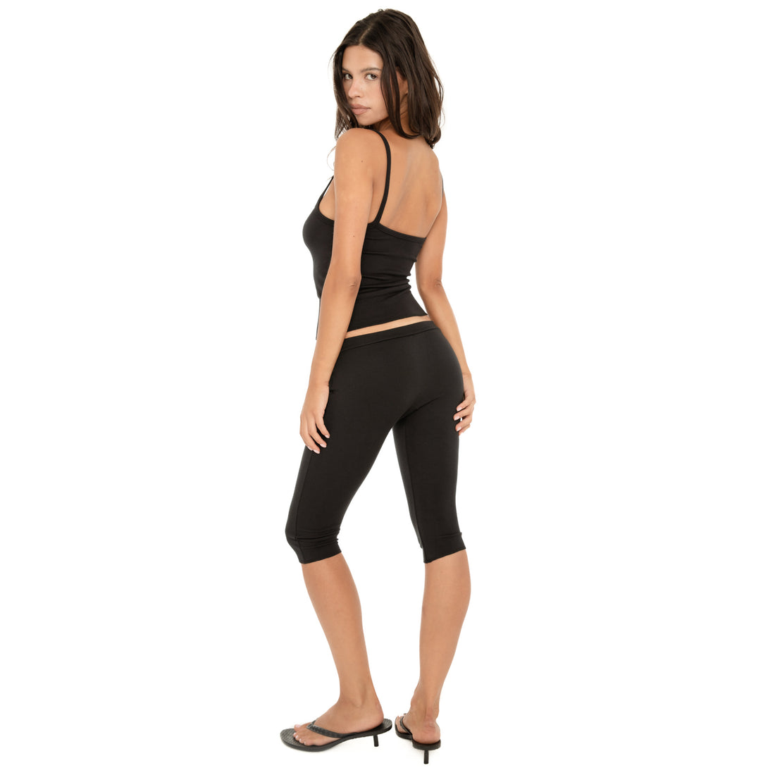 Back three-quarter view of the Miia Capri in Black, highlighting the low-rise waistband and fitted silhouette from behind **black