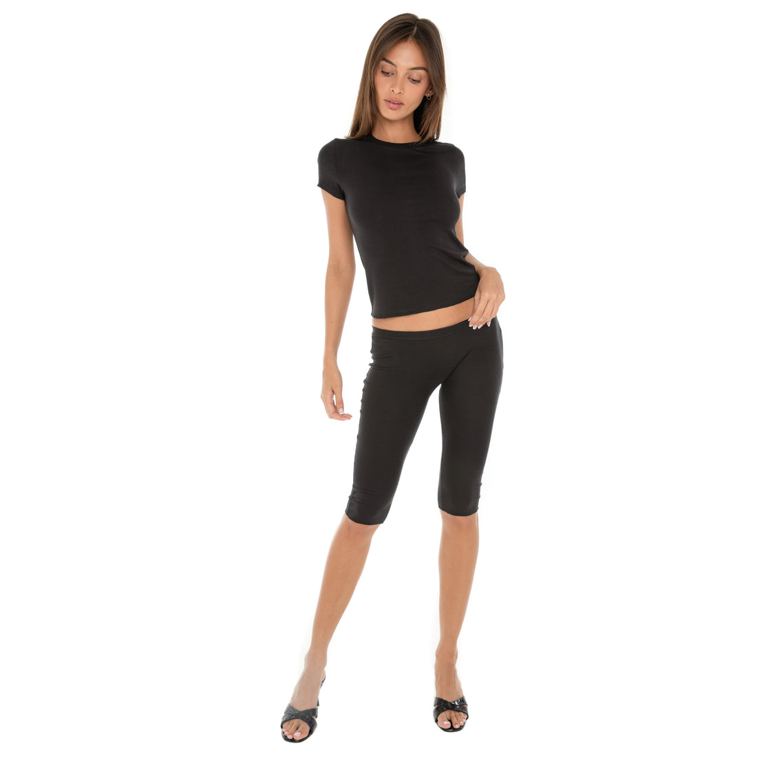 Full-body view of model in black Miia Tee and black Miia Capri pants with heels.