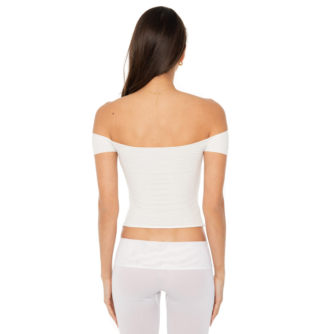 Model wearing the Ilze Top in white, an off-the-shoulder fitted jersey top made of lightweight cotton-spandex blend with raw hems **white