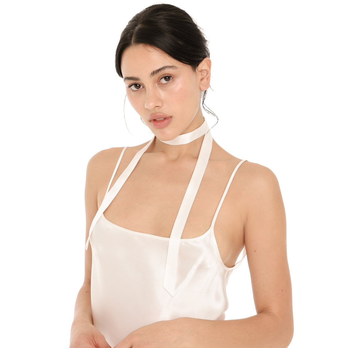 Close-up of the white silk Nida Choker wrapped around the neck, with two long, skinny tails falling down the front of the white silk Syra Camisole. **white