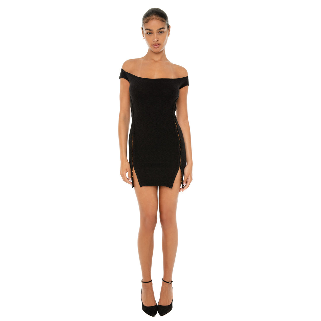 Model wearing the black miyu Dress — off-shoulder ribbed mini with gold hook-and-eye closures running down each side, hugging the body in a sculpted silhouette.**black