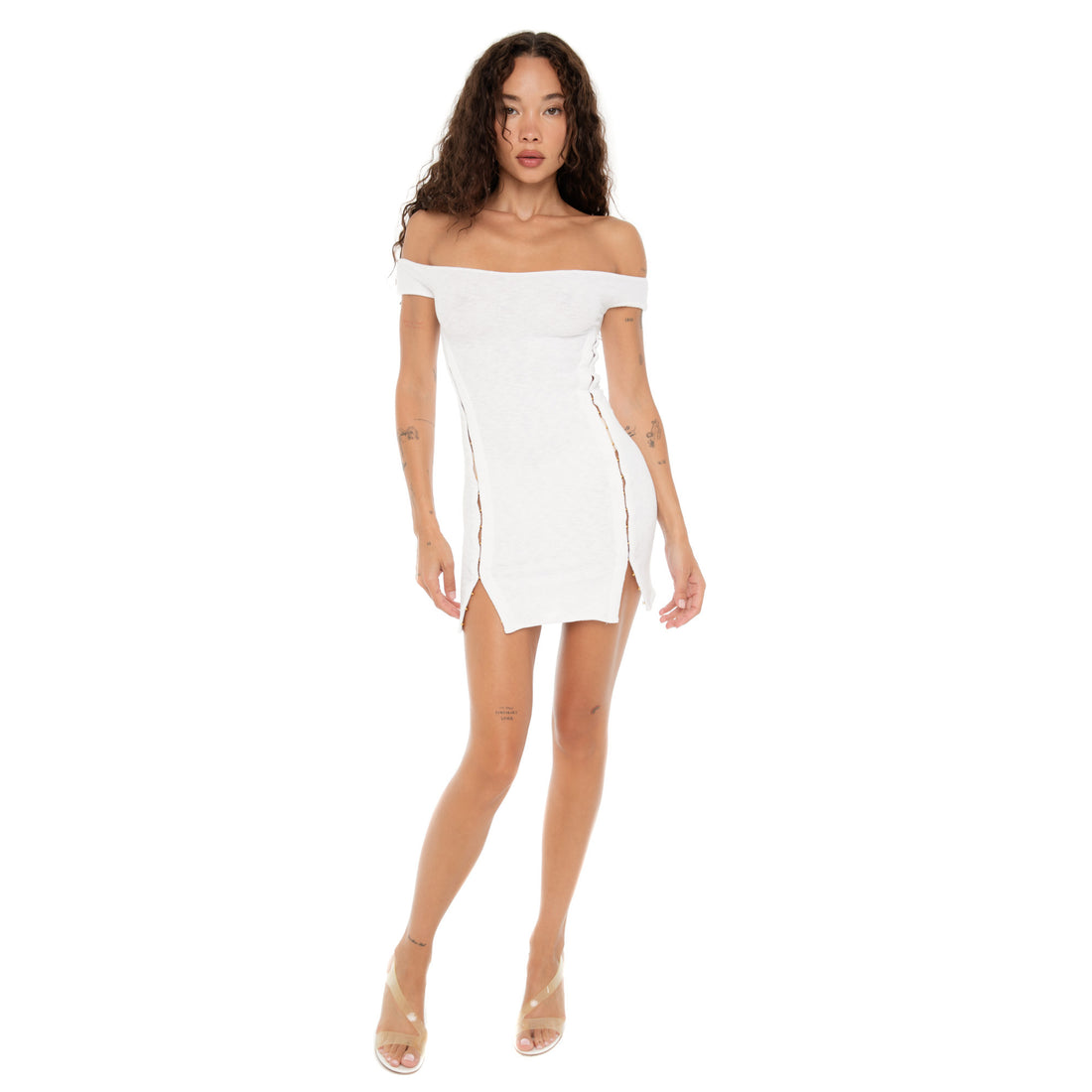 Front view of model wearing the Are You Am I Nikisa Dress in white, featuring an off-the-shoulder neckline and gold hook-and-eye detailing down the sides. **white