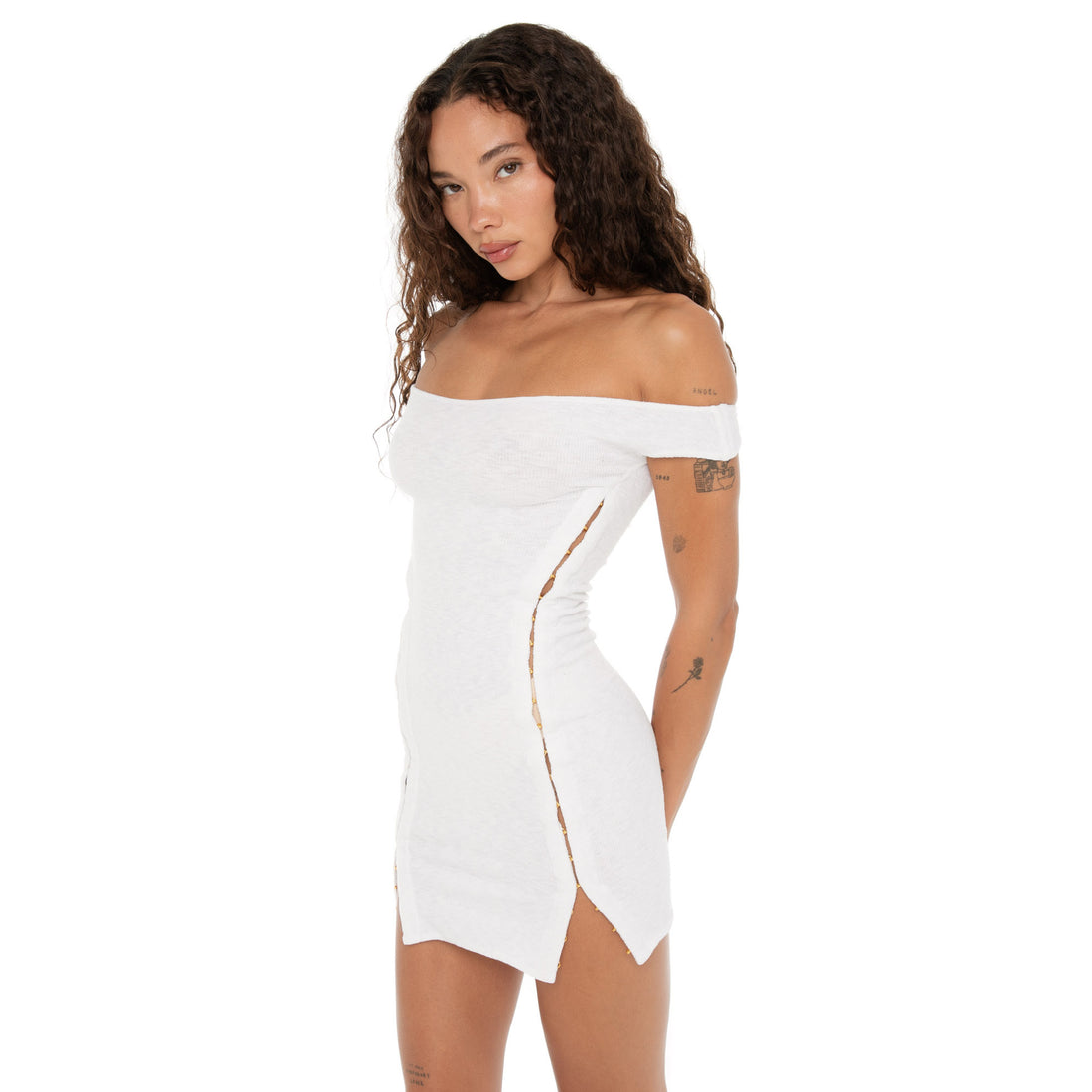 Side view of the Nikisa Dress in white on model, displaying the full length of hook-and-eye closures from underarm to hem. **white
