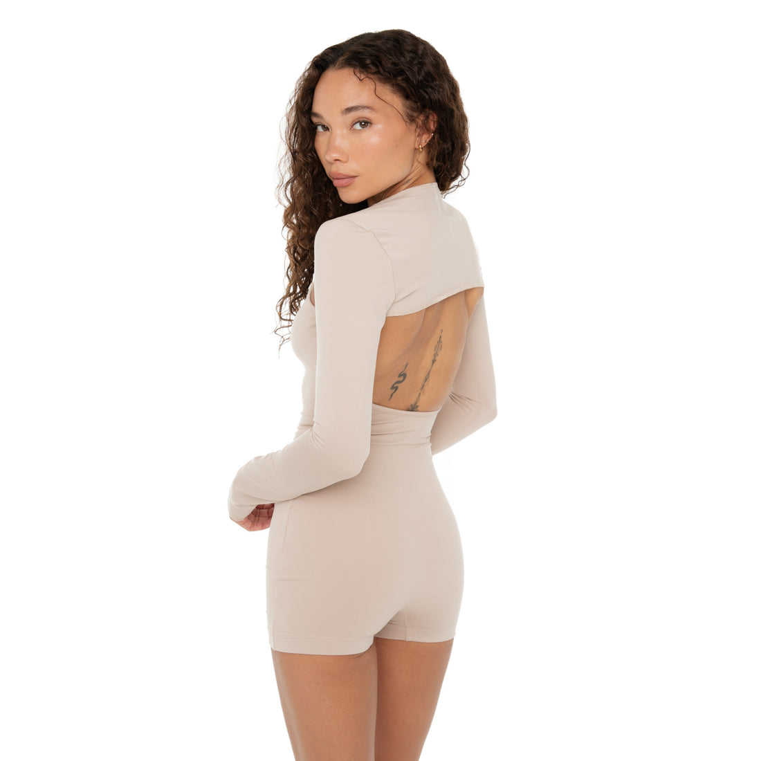 Back view of Nyan Shrug in nude revealing cropped cut with open back styling. **nude