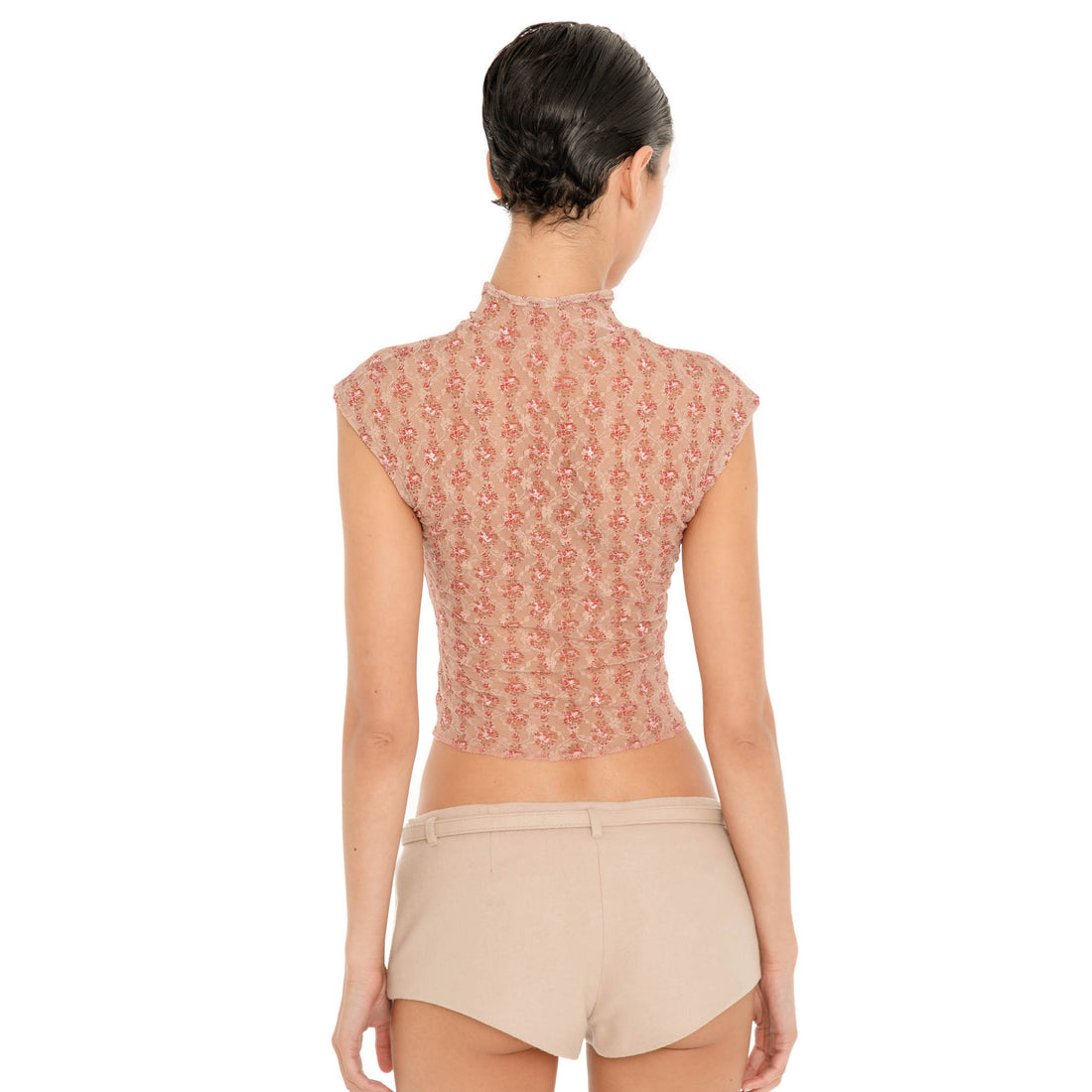 Back view of model wearing the Pika Short in Almond, showing the low-rise waist, belt loops, minimal back coverage and close fit. **almond