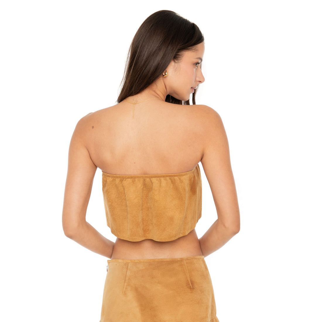 Model wearing the Etra Top — a strapless suede top that drapes from the bust, undulating in a uniform fit around the torso, lined in 100% silk **butterscotch