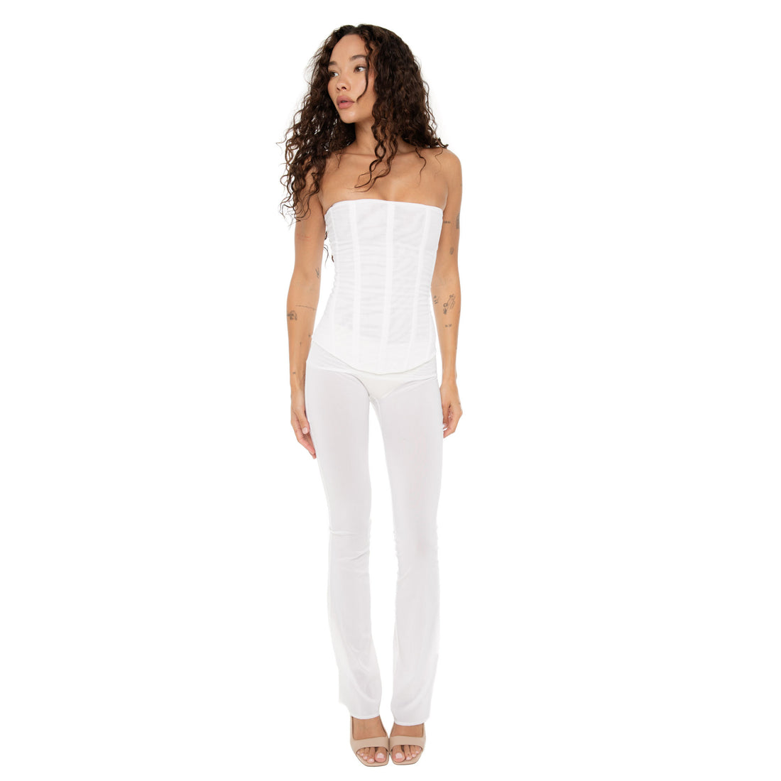 Model standing in white mesh Sunniva pants and white corset, looking to the side **white