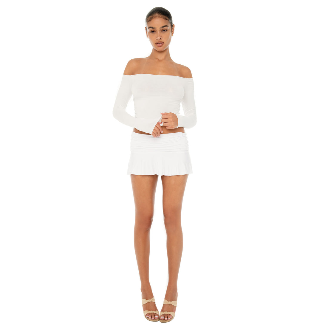 Model wearing the Naia Skirt — a low-rise mini in ultra-soft modal with spandex stretch, designed to sculpt the waist with a sleek, minimal fit.**white