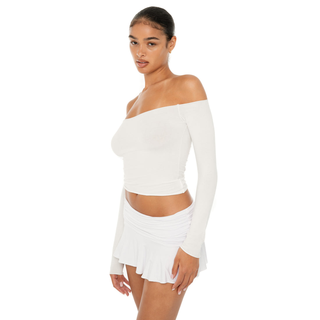 Model wearing the Naia Skirt — a low-rise mini in ultra-soft modal with spandex stretch, designed to sculpt the waist with a sleek, minimal fit.**white