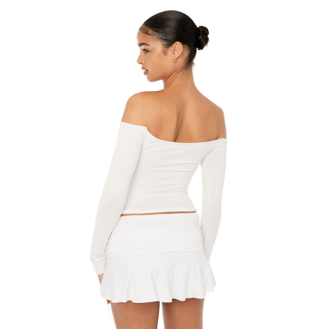 Model wearing the Naia Skirt — a low-rise mini in ultra-soft modal with spandex stretch, designed to sculpt the waist with a sleek, minimal fit.**white