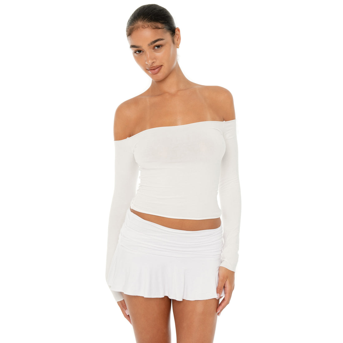 Model wearing the Naia Skirt — a low-rise mini in ultra-soft modal with spandex stretch, designed to sculpt the waist with a sleek, minimal fit.**white