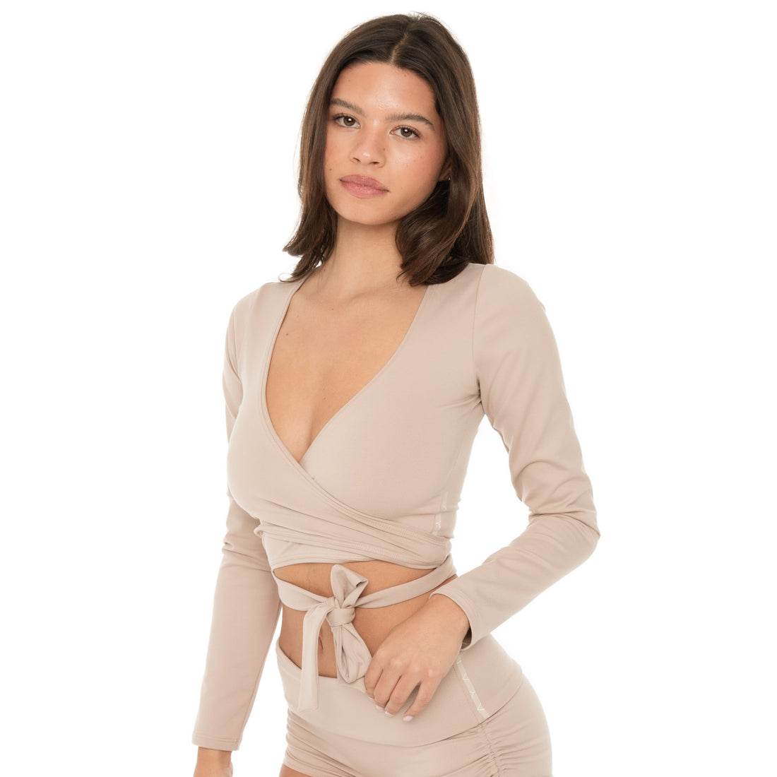 Three-quarter front view of nude active wrap top with waist tie and ruched shorts **nude
