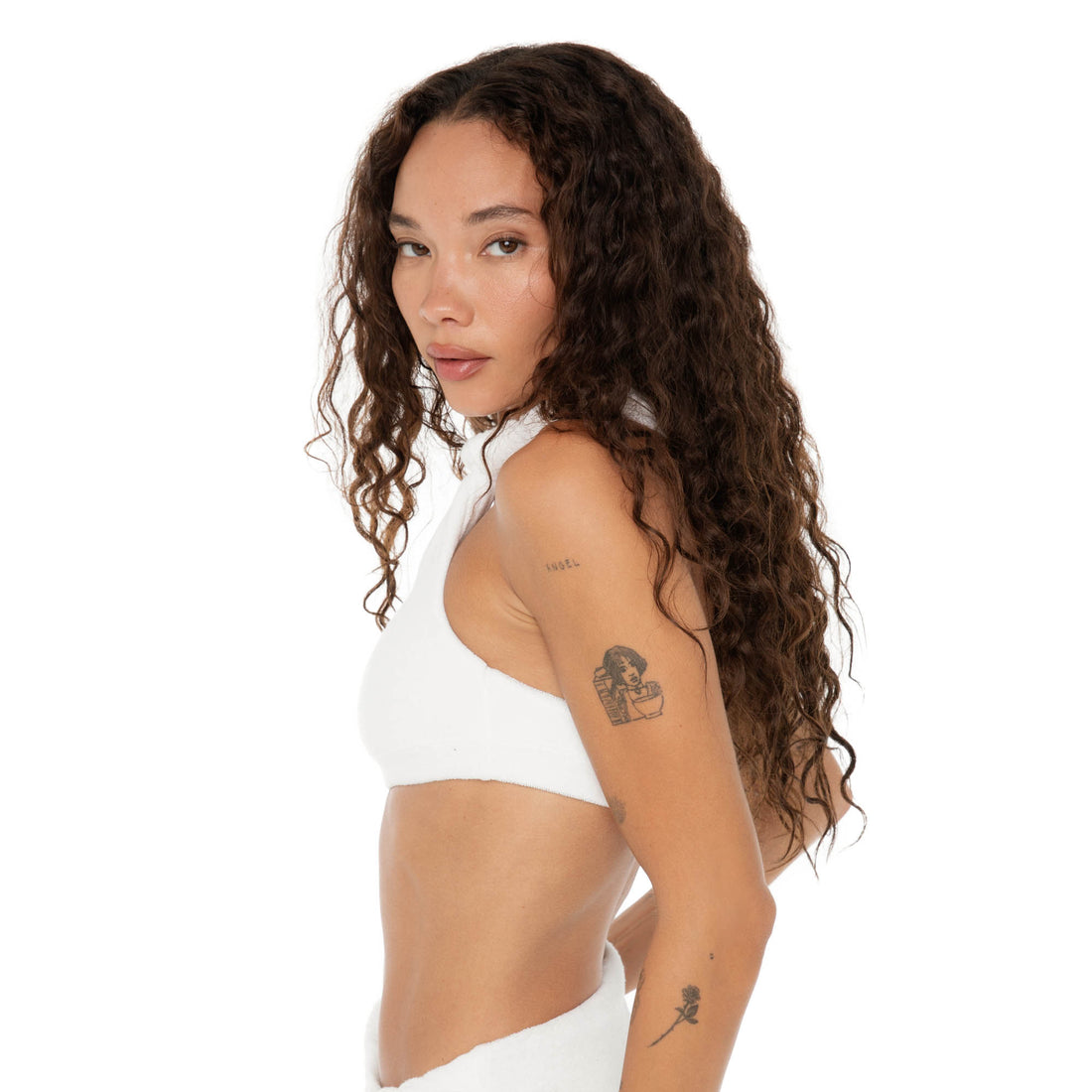 Side view of model in the Aimi Bikini Top, showing the plush terry texture and slim elastic hem under the bust. **white