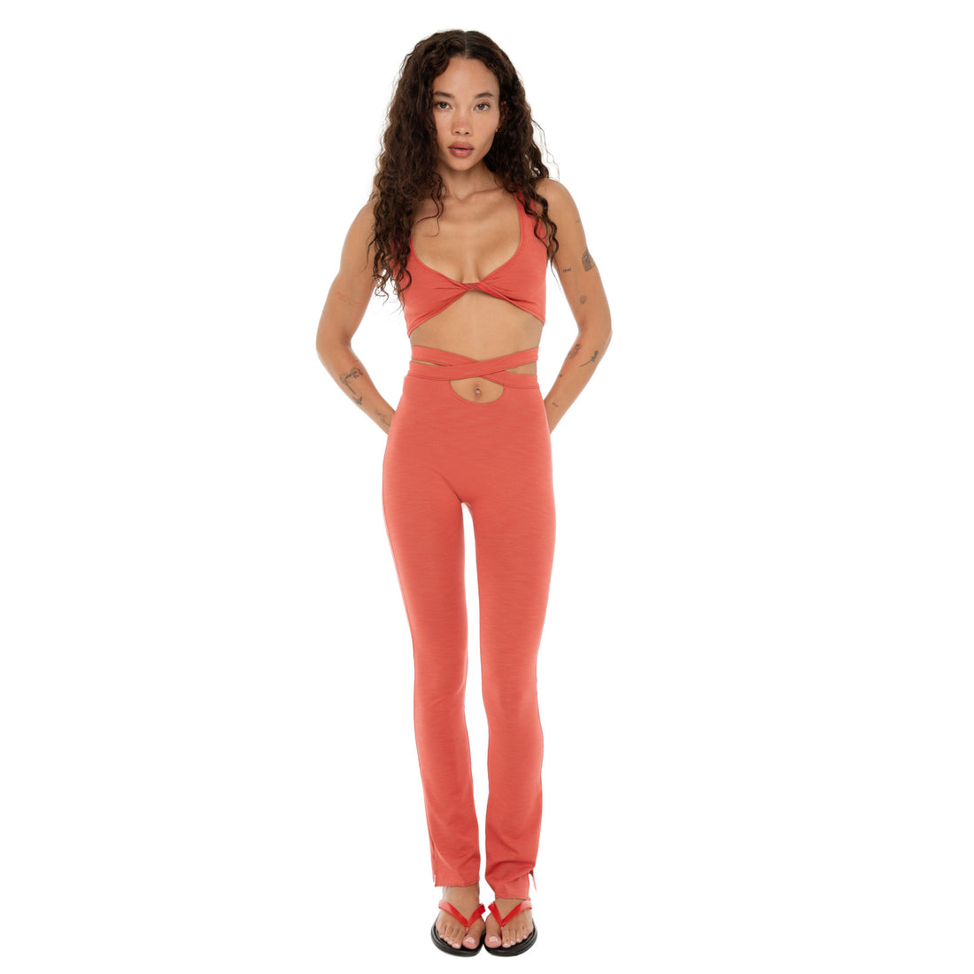 Full-length front view of model wearing Alda Legging in cayenne with wrap tie waist and bootcut leg. **cayenne