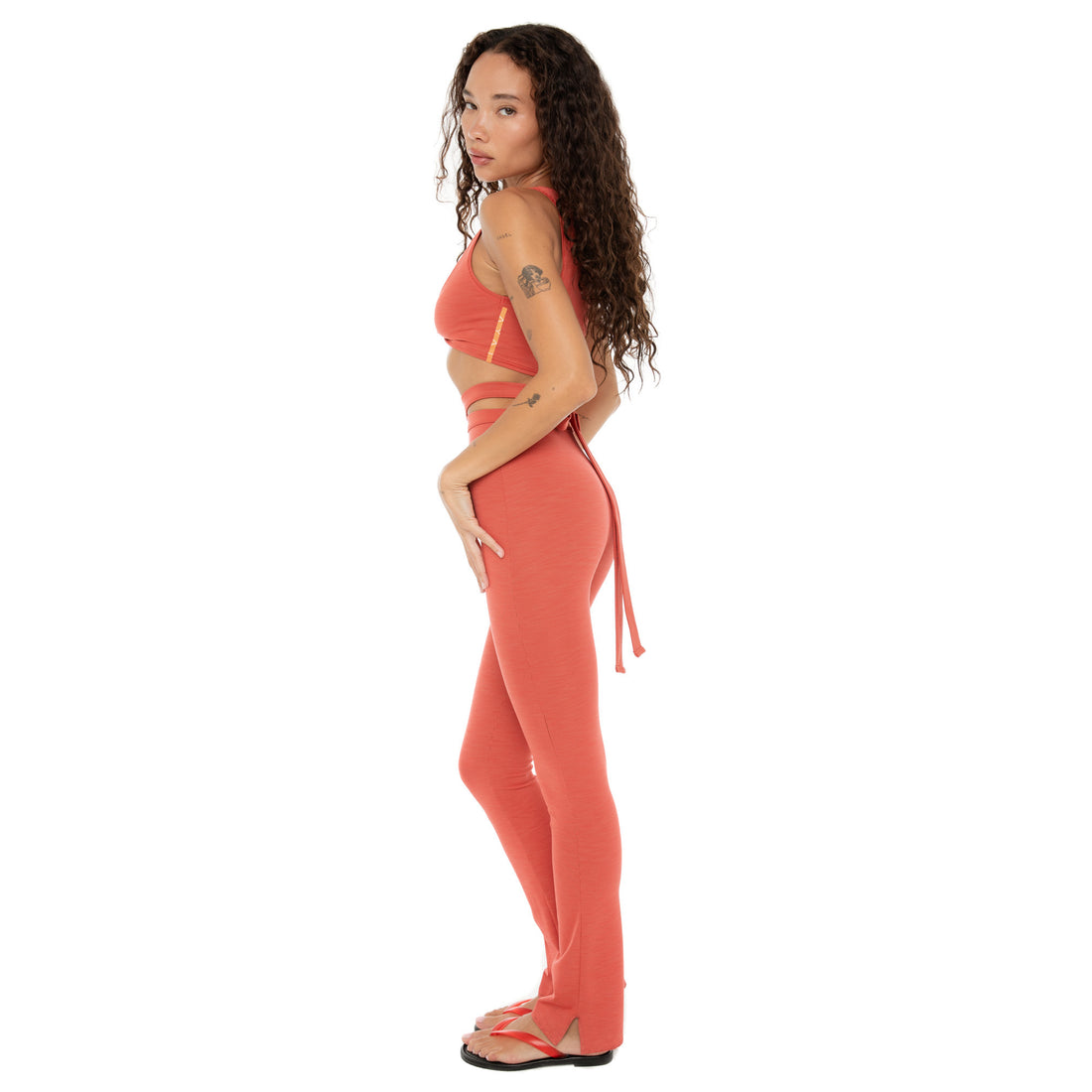 Side angle of Alda Legging in cayenne showing slim fit and waist tie detail. **cayenne