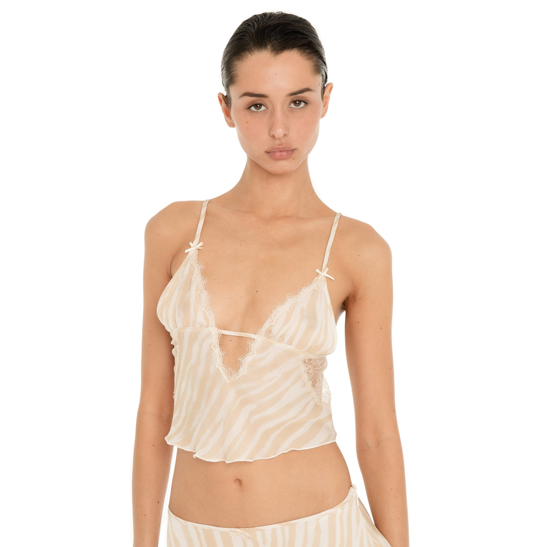 Front detail of the Are You Am I Aria Camisole in Ivory Latte, showing the plunging lace-trim neckline, bow details, sheer zebra print and thin straps. **ivory-latte