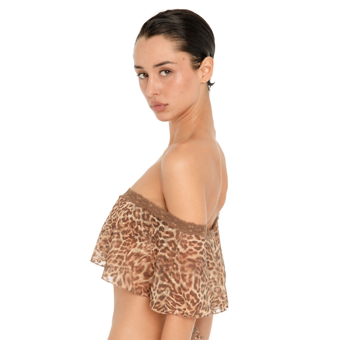 Close side view of the Liulu Leopard Top, highlighting the off shoulder neckline, brown lace trim, sheer leopard print fabric and loose ruffled silhouette
