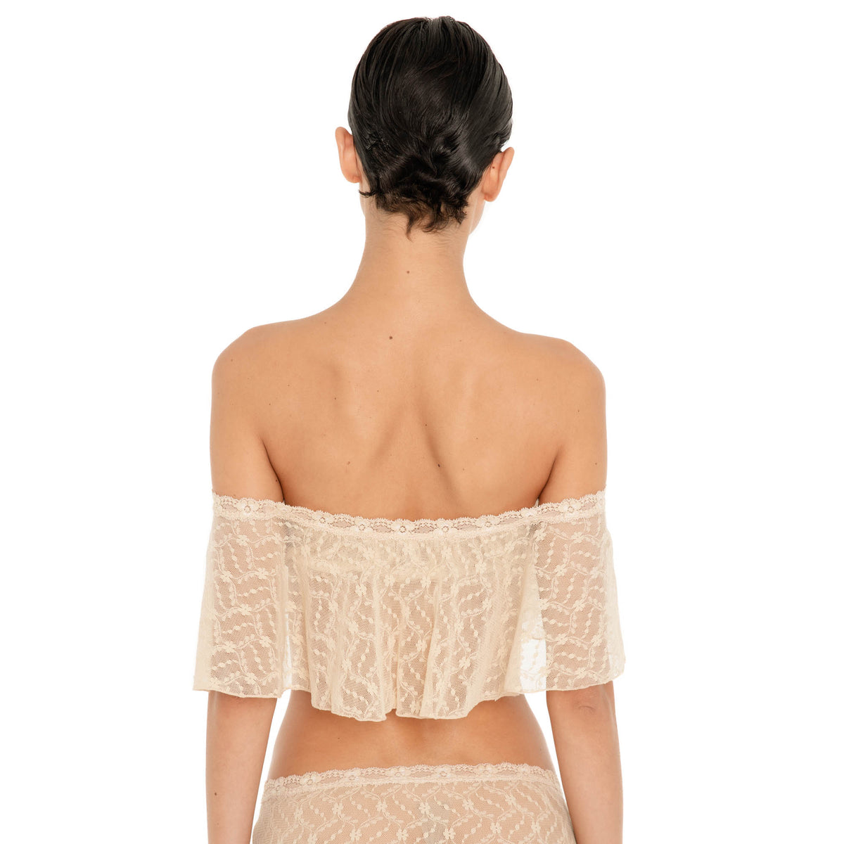 Back view of the Liulu Top in nude sheer lace with a wide off shoulder neckline and flowing cropped ruffle **nude