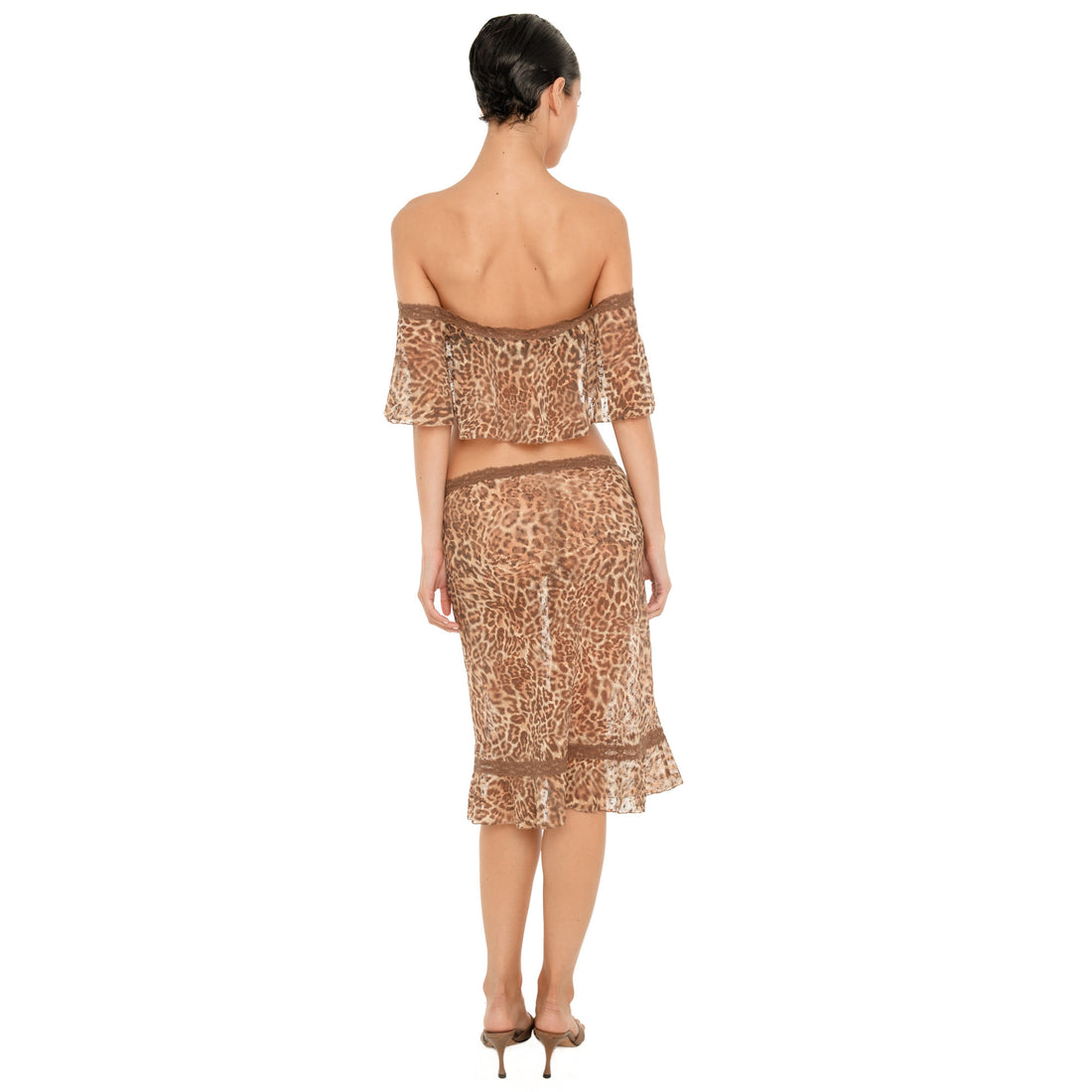 Back view of model wearing the sheer leopard Liulu Skirt, showing the low rise lace waistband, fitted silhouette and ruffled hem
