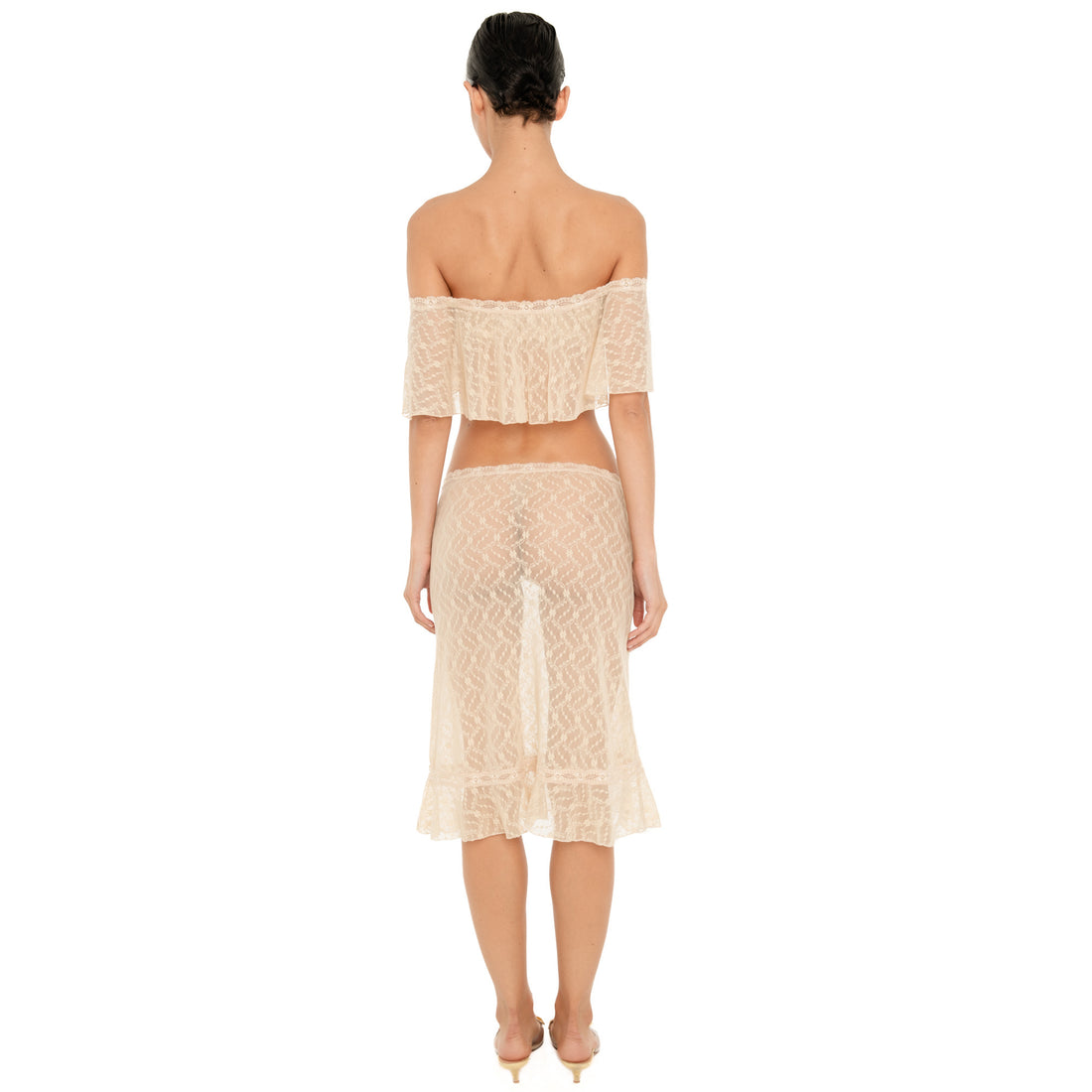 Back view of the Liulu skirt in nude, featuring sheer floral lace, a low rise waistband, midi length, and softly ruffled hem. **nude