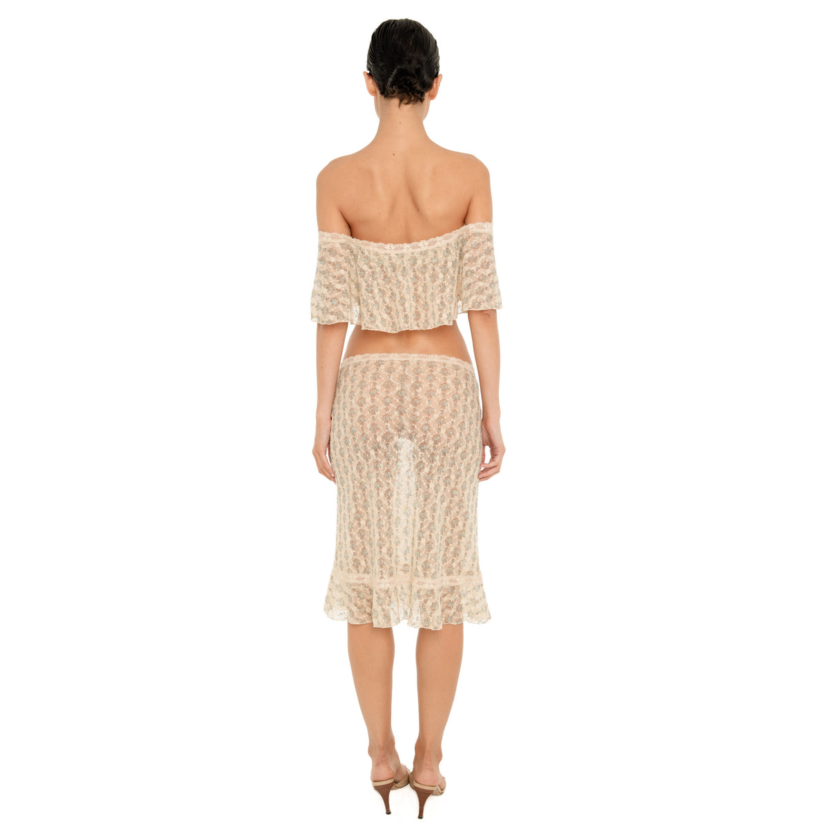 Back view of the Liulu skirt, a sheer cream floral lace midi skirt with a low-rise fit, lace waistband, and ruffled hem. **sky blossom