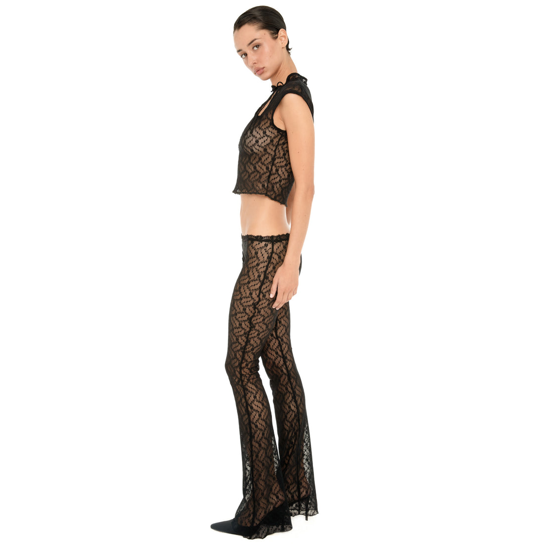 Side view of the Liani Pant in Black, showing the low rise lace-trimmed waist, sheer floral lace and flared hem. **black