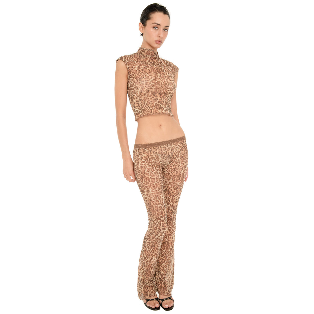 Model wearing the Liani Pant in Leopard, a sheer low rise lace pant with a slim flared leg, styled with a matching leopard top.