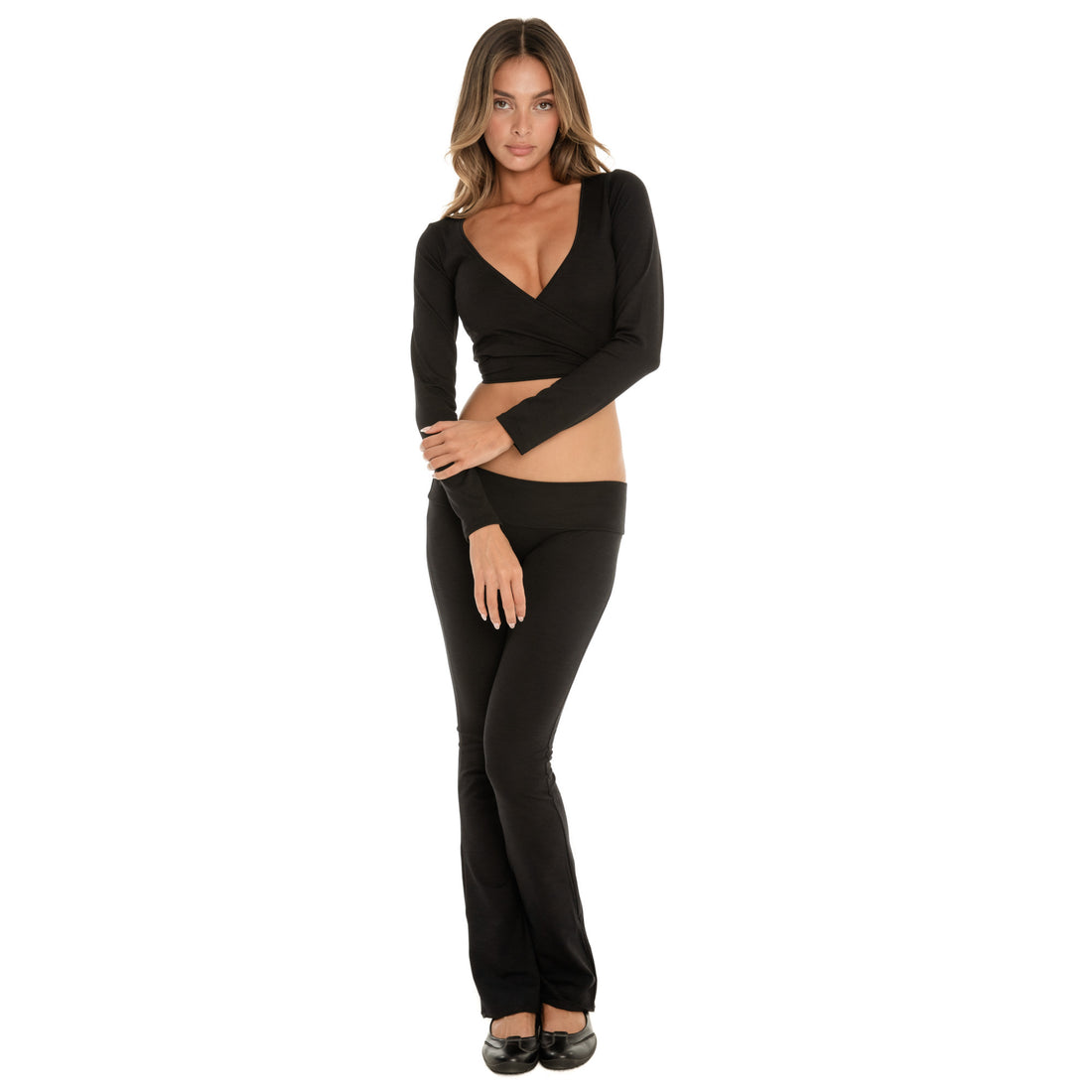 Front-facing model in the Clio Pant in black, highlighting the smooth waistband and flared leg, styled with the Nuka Top, relaxed stance **black
