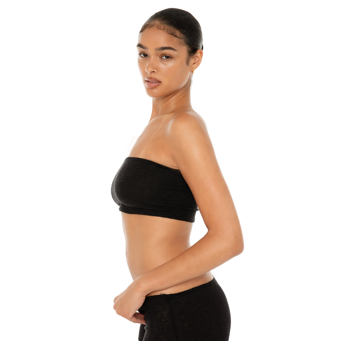 Side view of the Aili Tube in black, a strapless cropped tube top in lightweight ribbed knit **black
