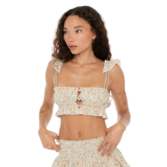 Model in the Are You Am I Eran Top floral print, featuring smocked fabric, ruffle details, and front button closures, paired with the Eran Skirt. **floral