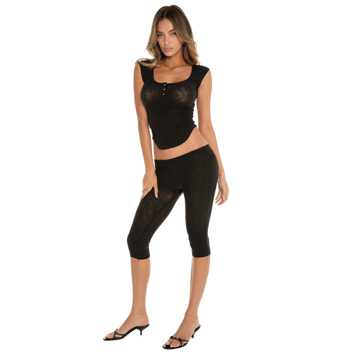 Three-quarter angled view of a fitted cap sleeve henley top and capri leggings, highlighting the sculpted fit and lightweight, breathable baby rib fabric **black