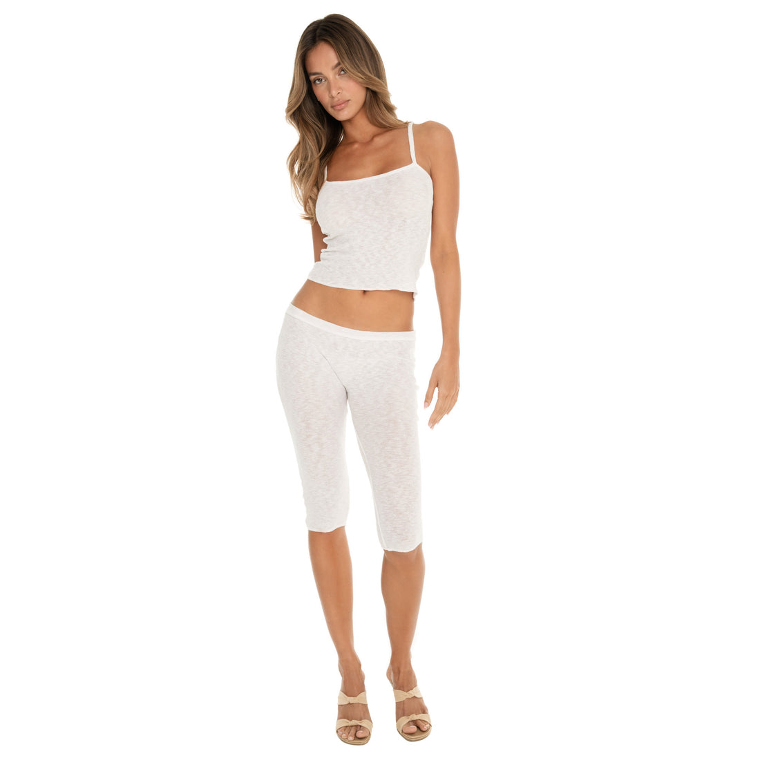 Woman standing front-facing wearing a white ribbed Illi tank with thin straps and matching capri pants, full body view with neutral stance **white